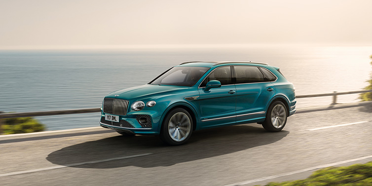 Bentley Seoul Bentley Bentayga Extended Wheelbase Azure SUV in Topaz blue paint driving dynamically by the ocean